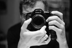 Selfie of Greg Pak taken in a mirror with this camera and lens