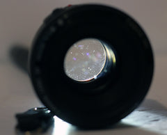 Canon EF 50mm f1.8 II lens with light shining through from behind to show some dust in the lens